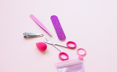 Obraz na płótnie Canvas Set of decorative cosmetics. Manicure tools . tweezers, nail scissors, emery, on pink background. copy space for text