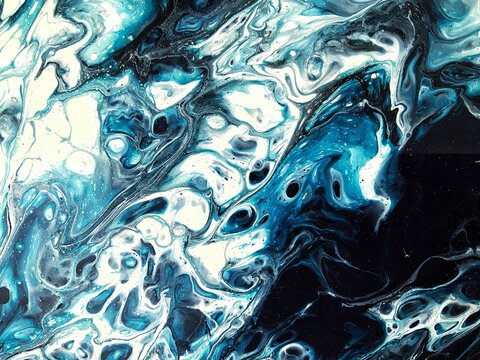 Fluid acrylic hand painting close up. Abstract art, liquid painting, babbles, wave, foam, sea, water, underwater, smoky, space. Blue, black and white paint, wallpaper, poster, background, backdrop