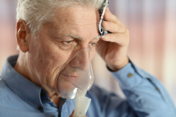 Portrait of  sick senior man with inhaler