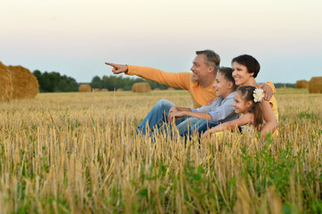 Happy family in summer field. man pointing with finger