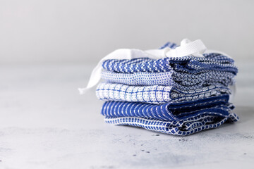 Textiles. Napkins made of cotton for home and serving in blue with a different pattern are stacked on a light background with a copy of the space.