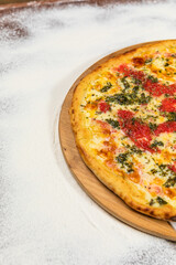 Pizza Homemade Artesanale Close Up Detail on a Round Wooden Plate with Flour Background Table