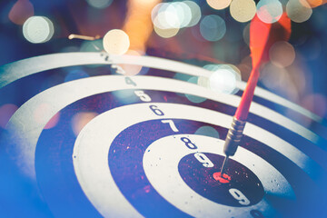 Close up shot of the dart arrow hit on bulleyes of dartboard to represent that the business reached...