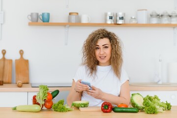 Obraz na płótnie Canvas Young woman preparing vegetable salad in her kitchen. Healthy lifestyle concept beautiful woman with mixed vegetable.