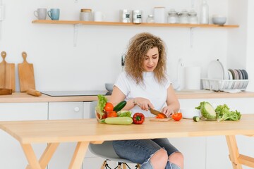 Young woman preparing vegetable salad in her kitchen. Healthy lifestyle concept beautiful woman with mixed vegetable.