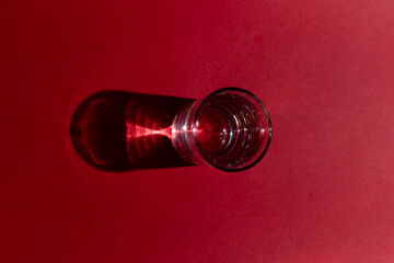 Glass of water with red background