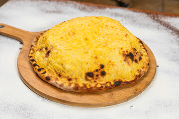 Calzone Pizza Homemade Artesanale Close Up Detail on a Round Wooden Plate with Flour Background Table