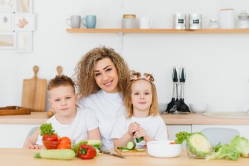 Family in a kitchen. Beautiful mother with children. Lady in white blouse.