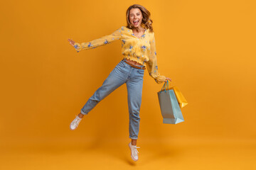 beautiful attractive smiling woman in yellow shirt and jeans with shopping bags