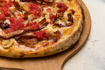 Bacon and Cheese Pizza with Rustic Tomato Sauce Homemade Artesanale Close Up Detail on a Round Wooden Plate with Flour Background Table