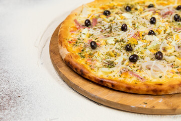 Pizza Ham Cheese Eggs and Olives Homemade Artesanale Close Up Detail on a Round Wooden Plate with Flour Background Table