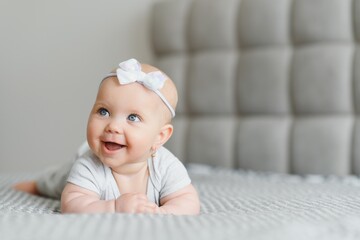 A Baby girl in white bedding at home look nice