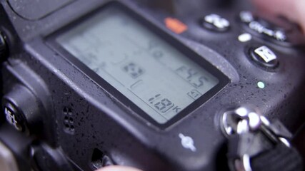 Photographer holding DSLR camera adjusting settings - close up