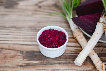 Mix spicy horseradish and beetroot saucer in a small glass jar on a rustic wooden table. Organic food. 
