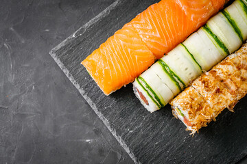appetizing set of sushi roll on a black stone plate