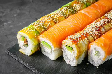 appetizing set of sushi roll on a black stone plate