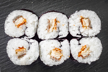 appetizing sushi roll maki with eel and unagi on a black stone plate