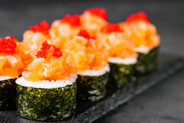 appetizing sushi roll maki with salmon on a black stone plate © Narsil