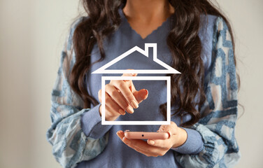 woman holding phone with house icon
