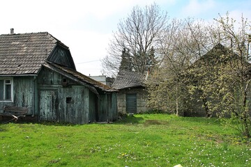 old rural buildings, wooden house, outbuildings, farm, green grass in front of the house, village