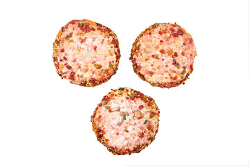 Raw meat patties with spices, three pork cutlets isolated on white
