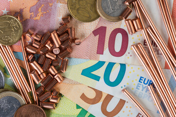 Euro banknotes, coins ans scrap of copper wire top view, trading and investing in raw metal...