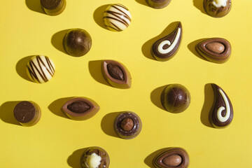 Top view of chocolate candies on a colored background. Chocolate Day Milk and Black Chocolates