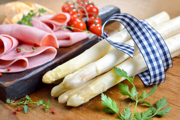 Bayerischer weißer Spargel vor der Zubereitung mit Schinken, Cherry-Tomaten und Gewürzen –...