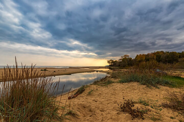 Fototapeta na wymiar Small lake near sea sand with sky reflection