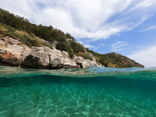Fototapeta premium Split underwater photo of exotic Caribbean island seascape with emerald sea and beautiful clouds