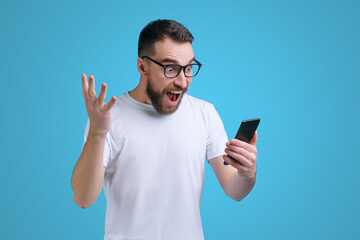 Guy being happy winning a bet in online sport gambling application on his mobile phone