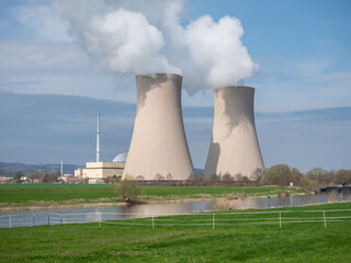 Nuclear power plant against sky by the river at sunset