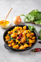 Aloo Palak sabzi - Potato cooked with spinach with added spices. A healthy Indian main course recipe. Served in a frying pan