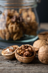 Heap of splited walnuts on rustic wooden table. vertical