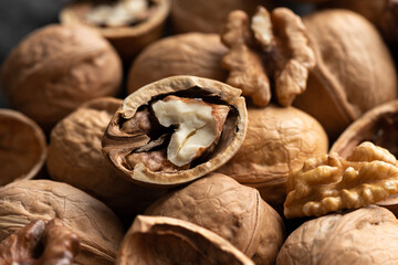 Tasty unshelled walnuts on heap of nuts. Close up view