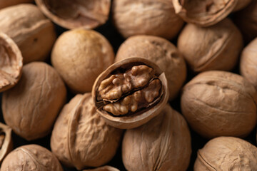 Tasty unshelled walnuts on heap of nuts. Close up view