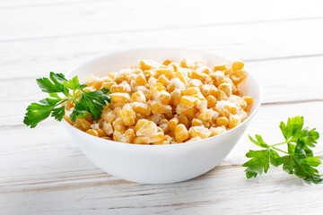 Frozen corn in a plate on white table. Frozen food