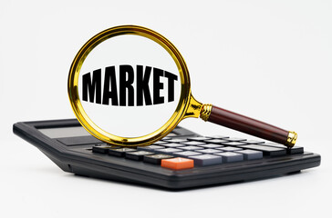 On a white background lies a calculator and a magnifying glass with the inscription - Market