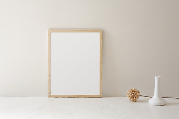 Minimalist style 11x14, thin wood frame mockup. Modern white vase with single artificial flower...