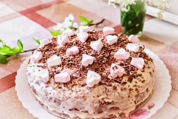 Fototapeta na wymiar Festive cake with cream and chocolate, decorated with hearts.