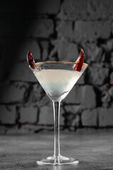 Cocktail in glass with chili on gray background. Devil alcohol drink.
