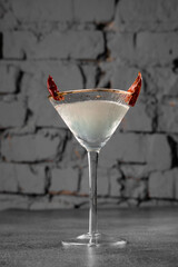 Cocktail in glass with chili on gray background. Devil alcohol drink.