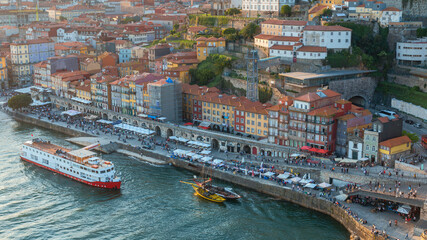Obraz premium top view of a cruise liner and a vintage boat for transporting port wine on the Douro river in the Portuguese city of Porto