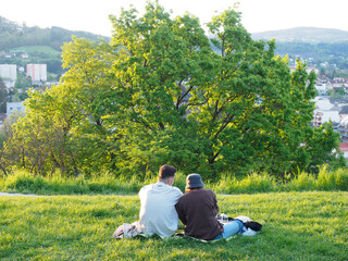 Liebespaar sitzt im Gras und genießt die Aussicht