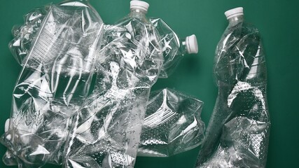 Heap of crumpled transparent PET plastic bottles ready for recycling. Used bottles from recyclable type of polymer. Environmental conservation problem due to plastic pollution of earth