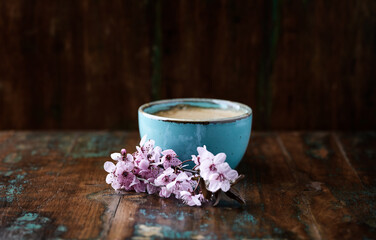 Spring flowers and Cappuccino on dark wooden background. Close up. 