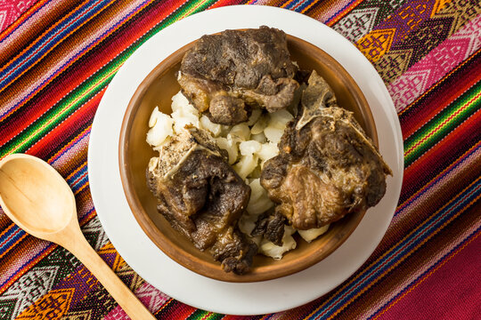 vista cenital de chicarrones de chanco con mote , comida peruana en bol artesanal y manto artesanal de fondo