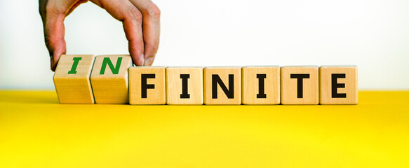 Finite or infinite symbol. Businessman turns wooden cubes and changes the word 'finite' to...