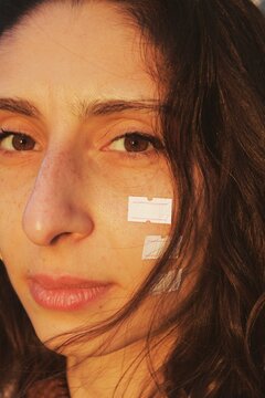 closeup portrait of young woman with white price tag labels on her face