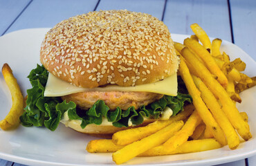 salmon burger top with swiss cheese and fries